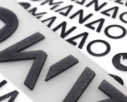 Schwarze 3D PVC-Applikationen mit Schrift auf Transferfolie – 1a-rubber.de