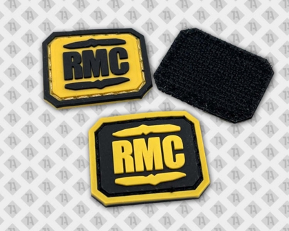 Drei gummierte Patches mit RMC-Schriftzug in Gelb und Schwarz.