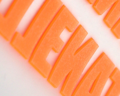 Detailaufnahme von oranger neon 3D-Schrift aus PVC – 1a-rubber.de