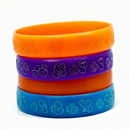 Bunte PVC-Armbänder mit geprägtem Text und Logos, gestapelt in verschiedenen Farben von 1a-rubber.de