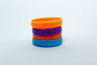 Stapel aus bunten PVC Armbändern mit geprägtem Design, ideal für Events, Festivals und Promotions.