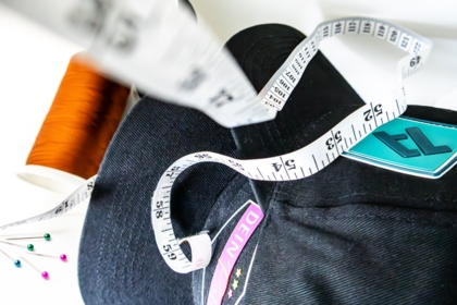 Aufgenähte Gummipatches auf Cap mit Maßband und Garn – Aufnähservice von 1a-rubber.de