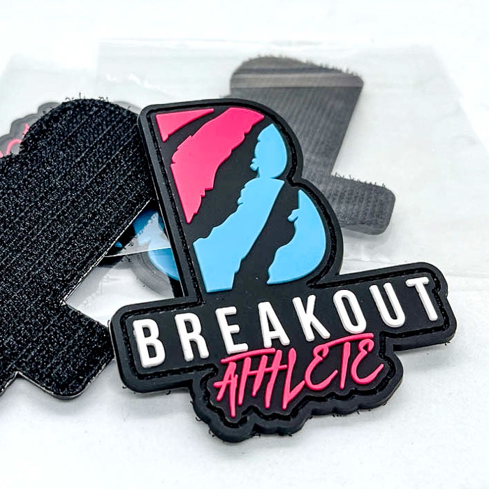 Schwarzer PVC-Patch mit Breakout Athlete Schriftzug in Blau, Pink und Weiß