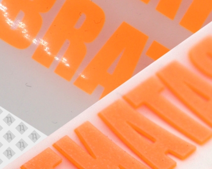 Leuchtend orange 3D PVC-Applikation mit Schriftzug – 1a-rubber.de